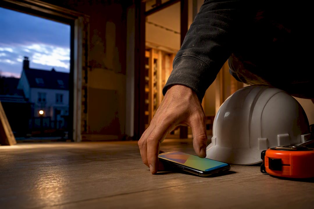Builder reviewing site records on smartphone