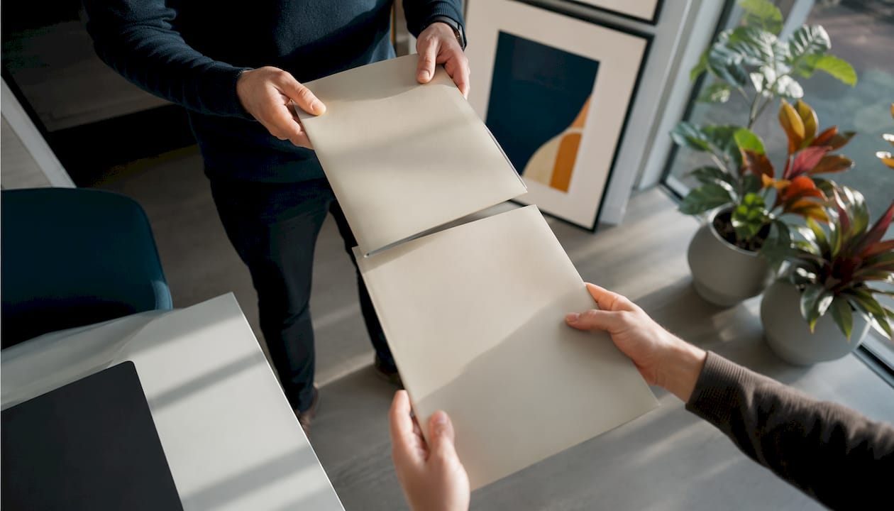 Op kantoor worden contracten uitgewisseld tussen collega's.