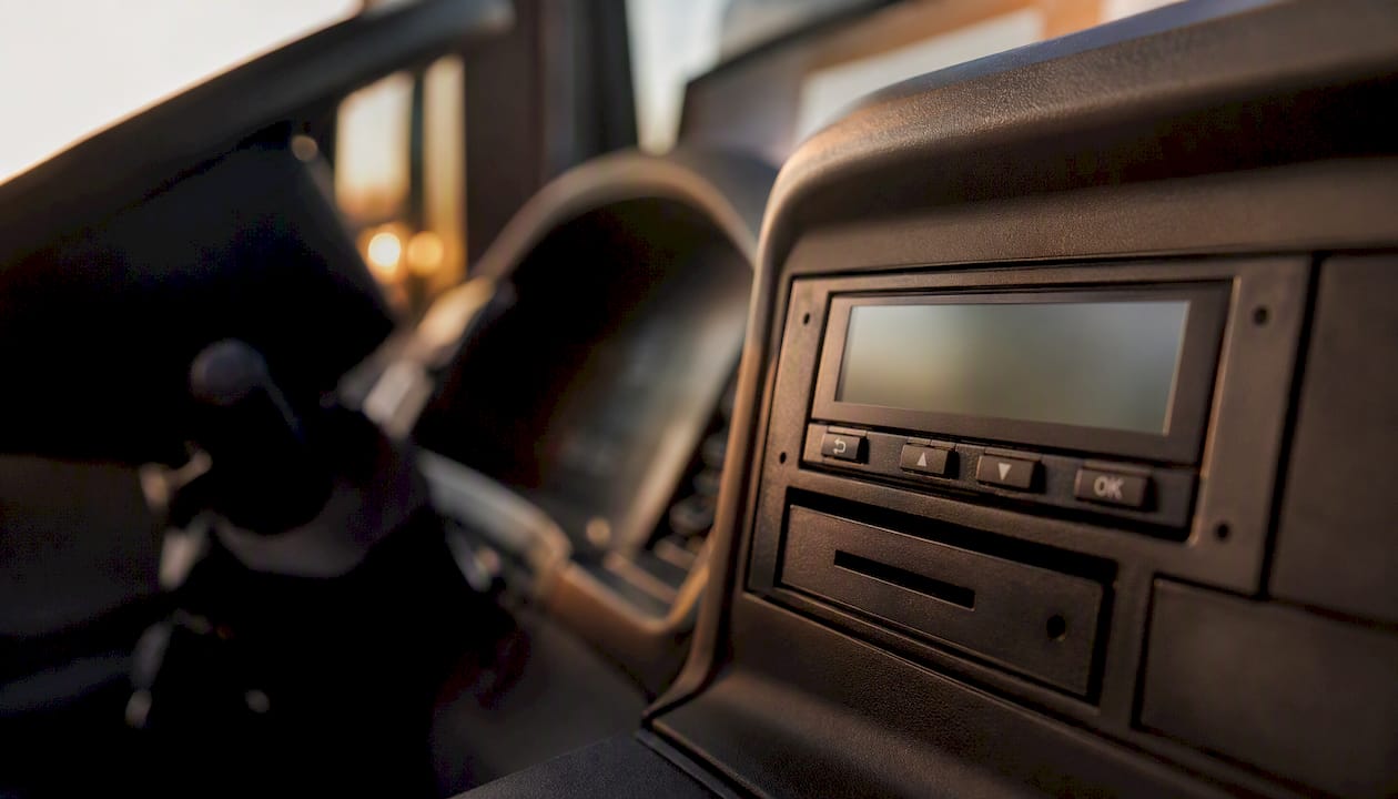 Close-up van het dashboard van een vrachtwagen met een goed zichtbare tachograaf.