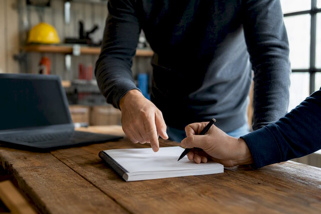 Handen wijzen naar een whiteboard met examengegevens