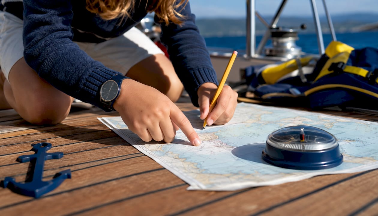 Children plotting course with nautical tools