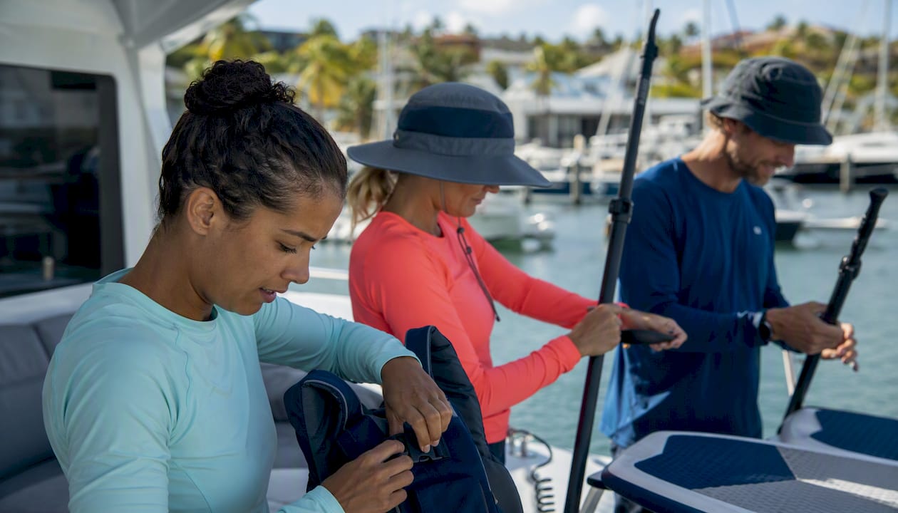 Group carrying paddleboards from yacht to water