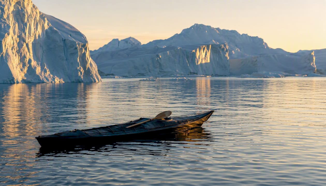 Iceberg-filled Ilulissat Icefjord with Inuit kayak foreground