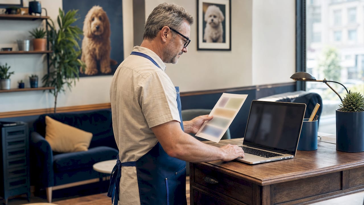 Groomer reviewing digital schedule at salon workstation