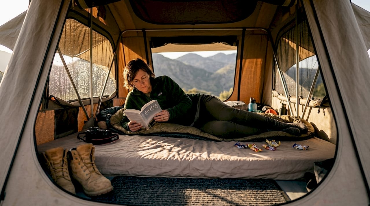 En person kopplar av inne i taktältet.