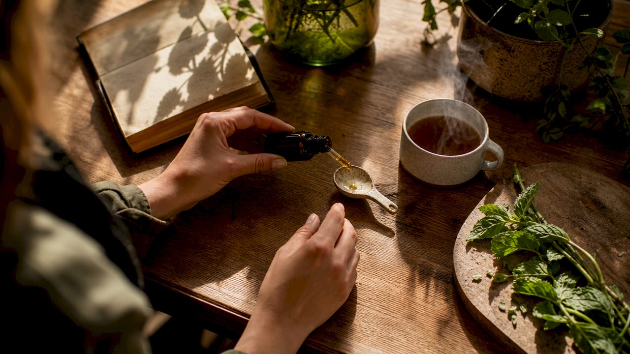 Hands measuring CBD oil for daily wellness routine