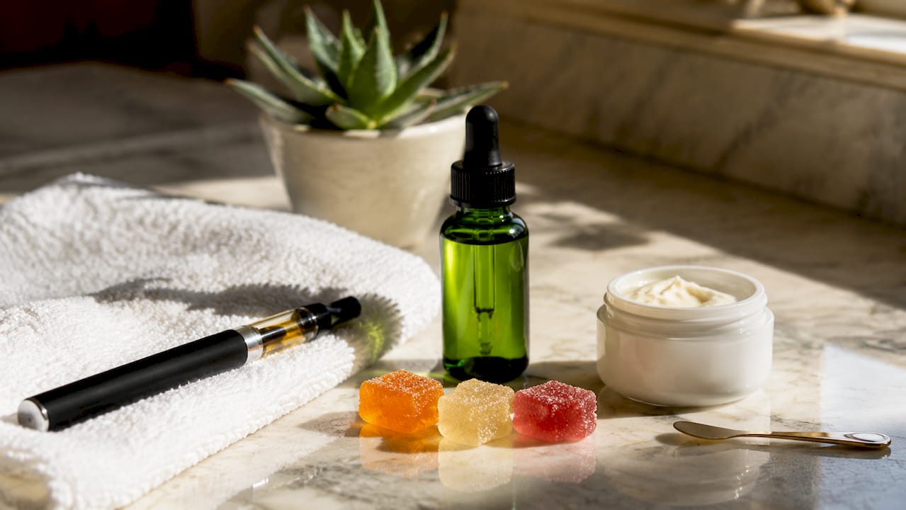 Top-down view of assorted CBD product types on wooden table