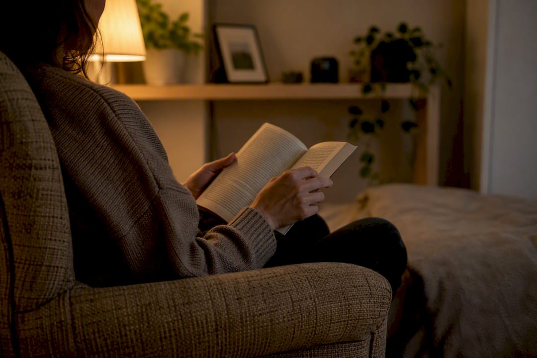 Hands reading a book in dim light