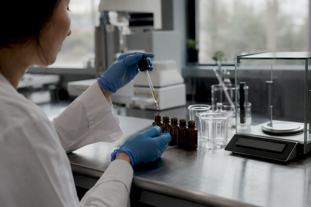 Technician handling CBD tincture bottles for testing