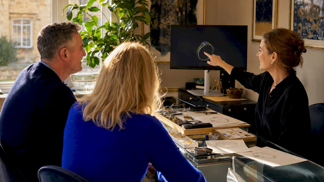 Couple consulting jeweller with design sketches