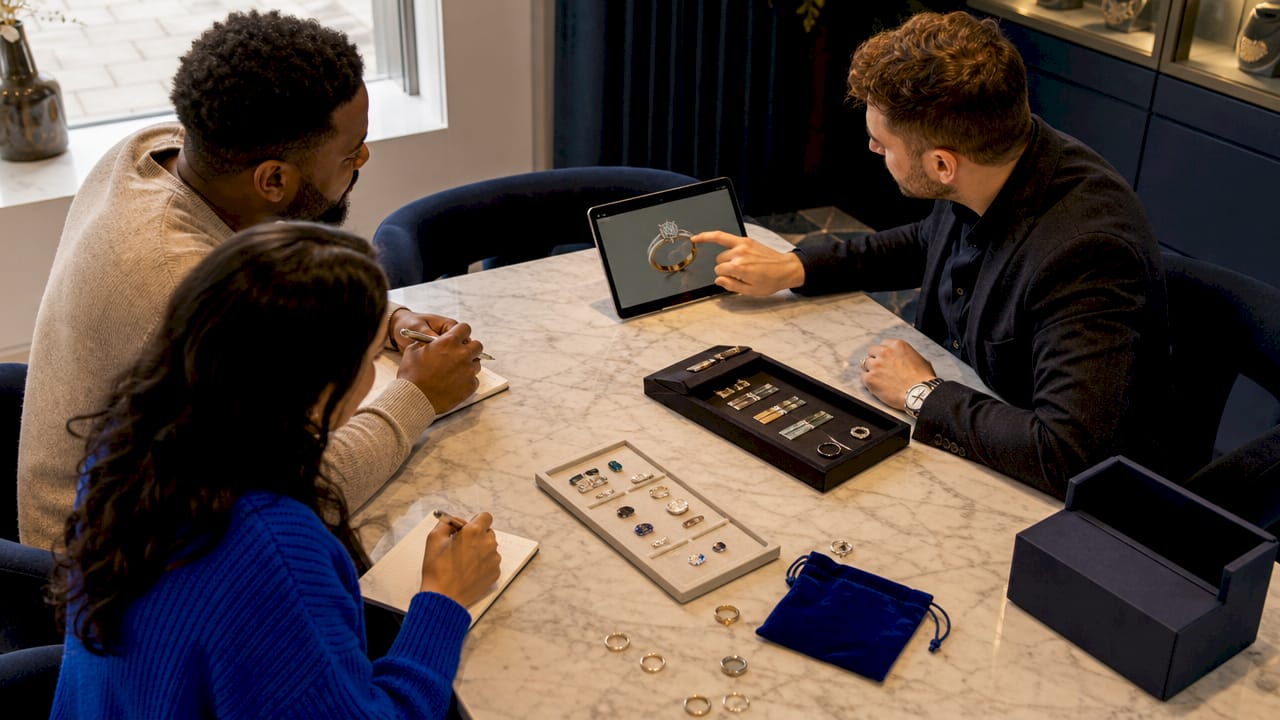 Couple consulting jeweller on custom ring options