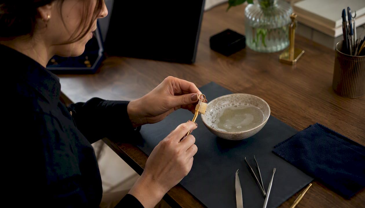 Hands gently cleaning vermeil ring