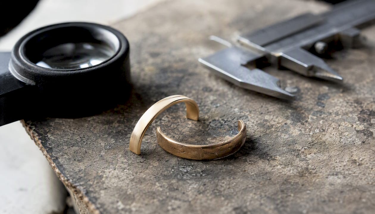 New gold metal stock beside worn ring shank
