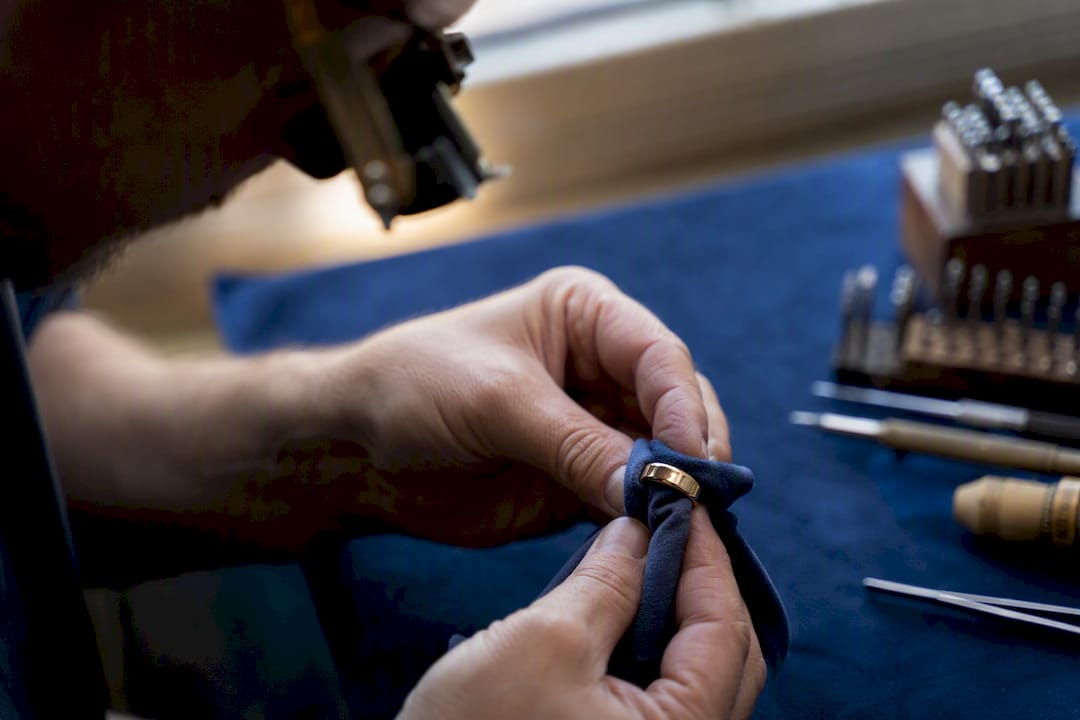 Hands polishing men's wedding ring