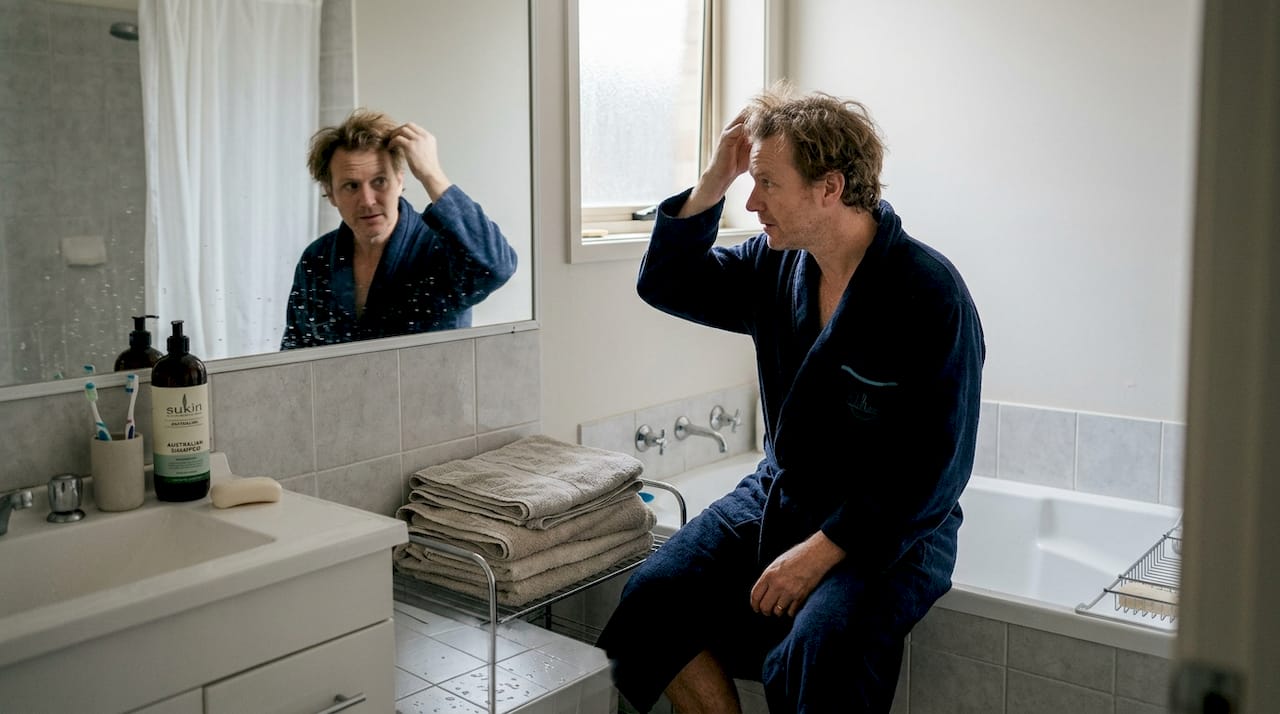 Man checking hair after shower water