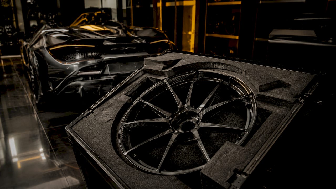 Packed BMW M5 wheel in foam-lined shipping crate under chiaroscuro lighting