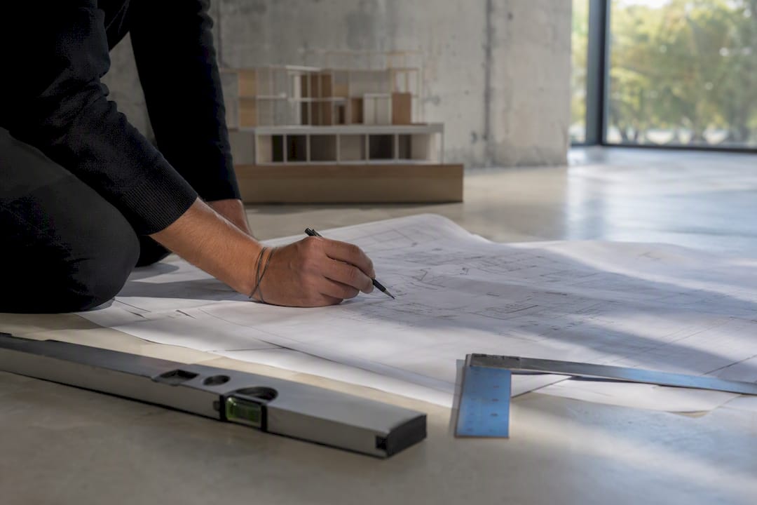 Un architecte ajuste les plans de rénovation parasismique sur la table