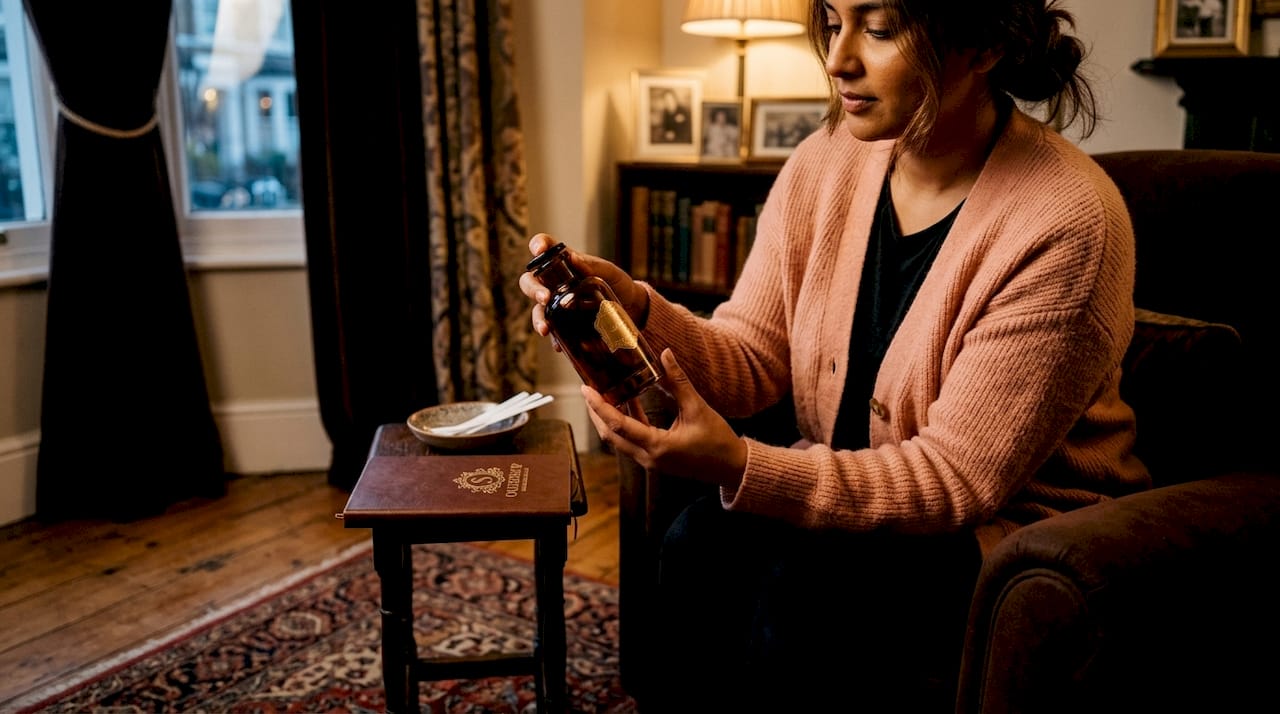 Inspecting oudh perfume bottle on kitchen counter