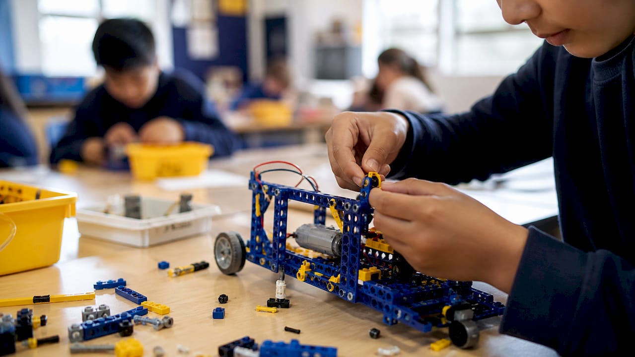 Dziecięce ręce składające zestaw edukacyjnego robota