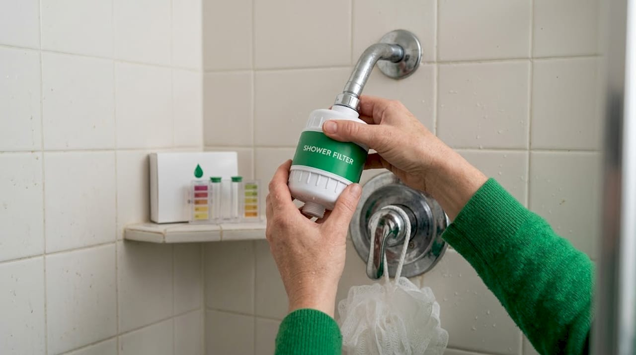Hands installing shower filter on fixture
