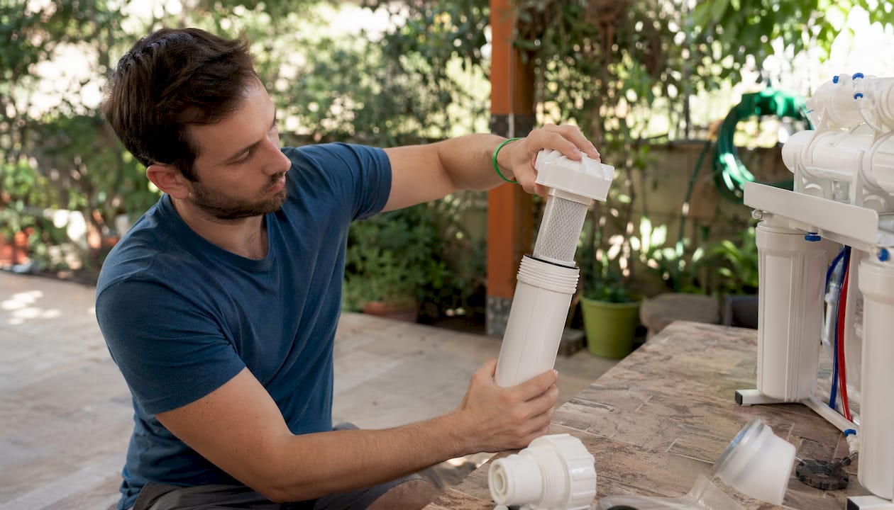Hands assembling water filter housing components