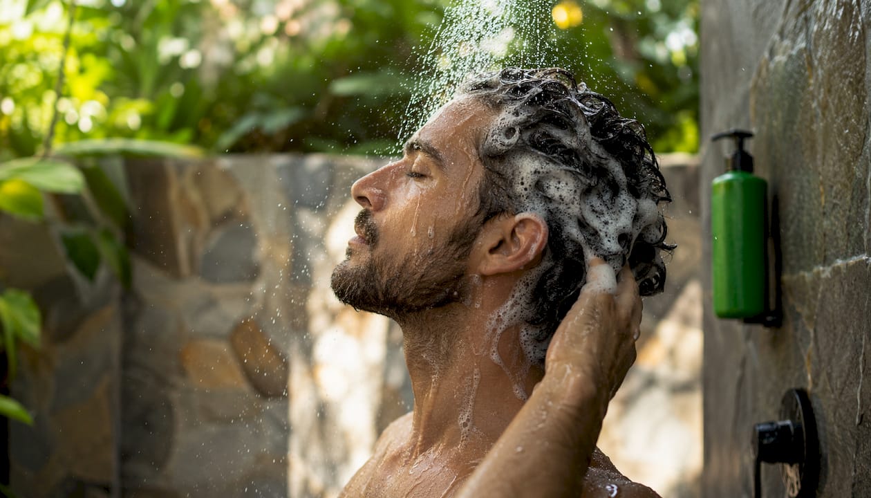 Man washing hair with hydrogen nano-bubbles in shower