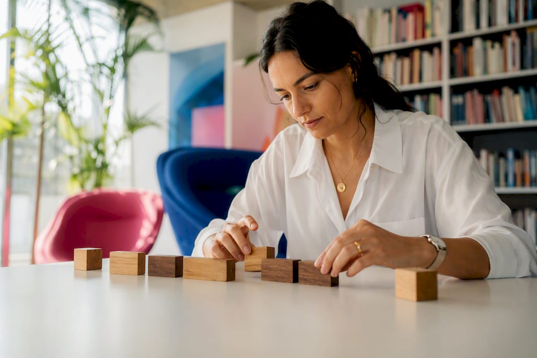 Person rearranging word blocks to invert phrase