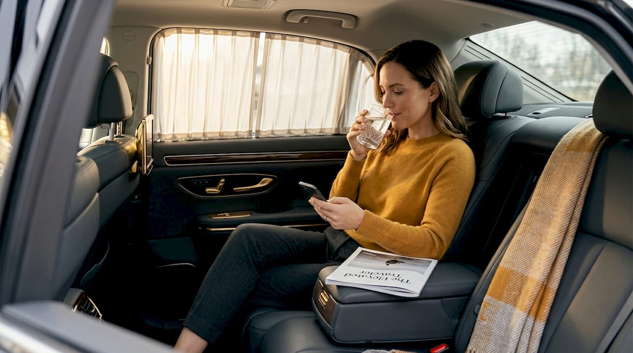 Business traveler relaxing inside luxury SUV