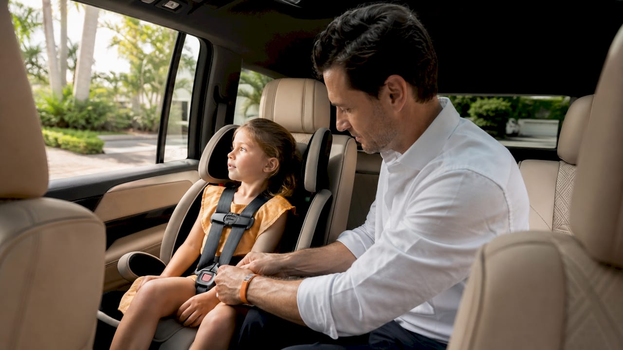 Father securing child seat in luxury van
