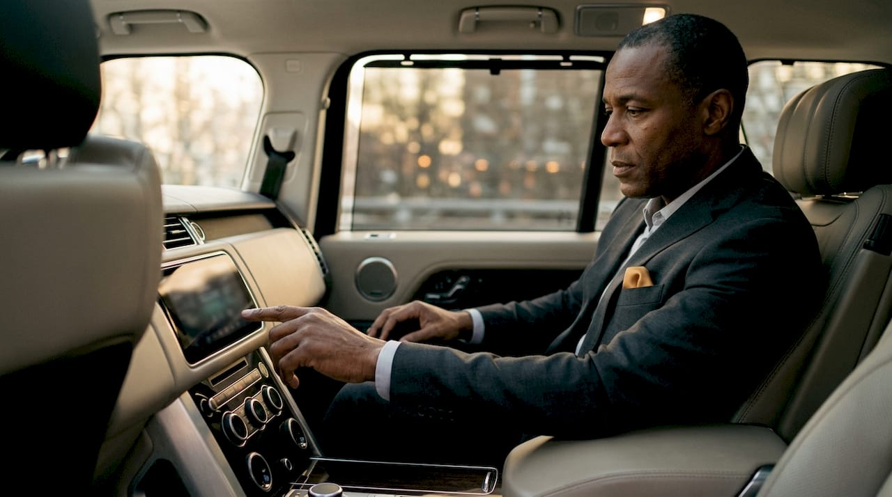 Man adjusting technology inside executive SUV