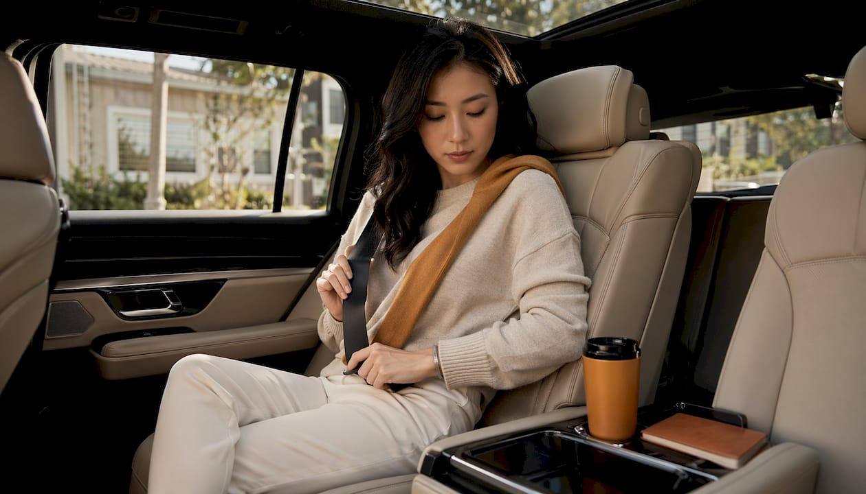 Woman adjusting seatbelt inside private car service