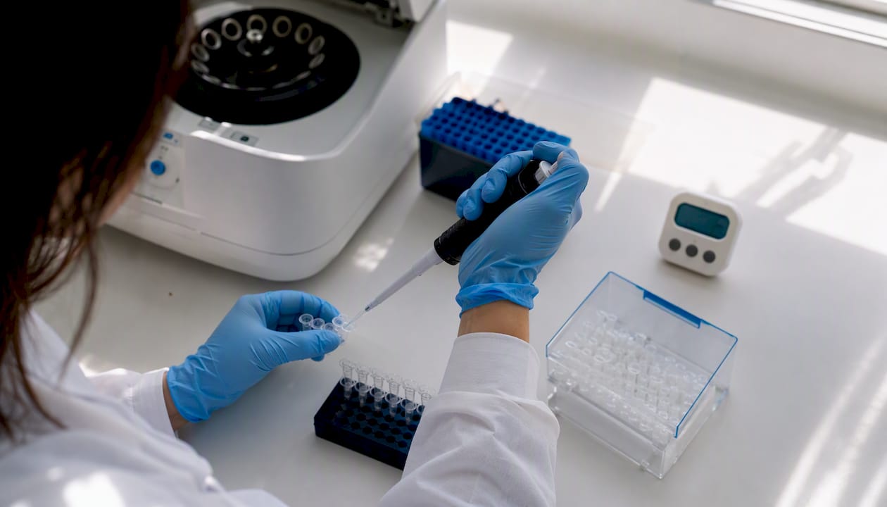 Scientist aliquoting reagents into PCR tubes