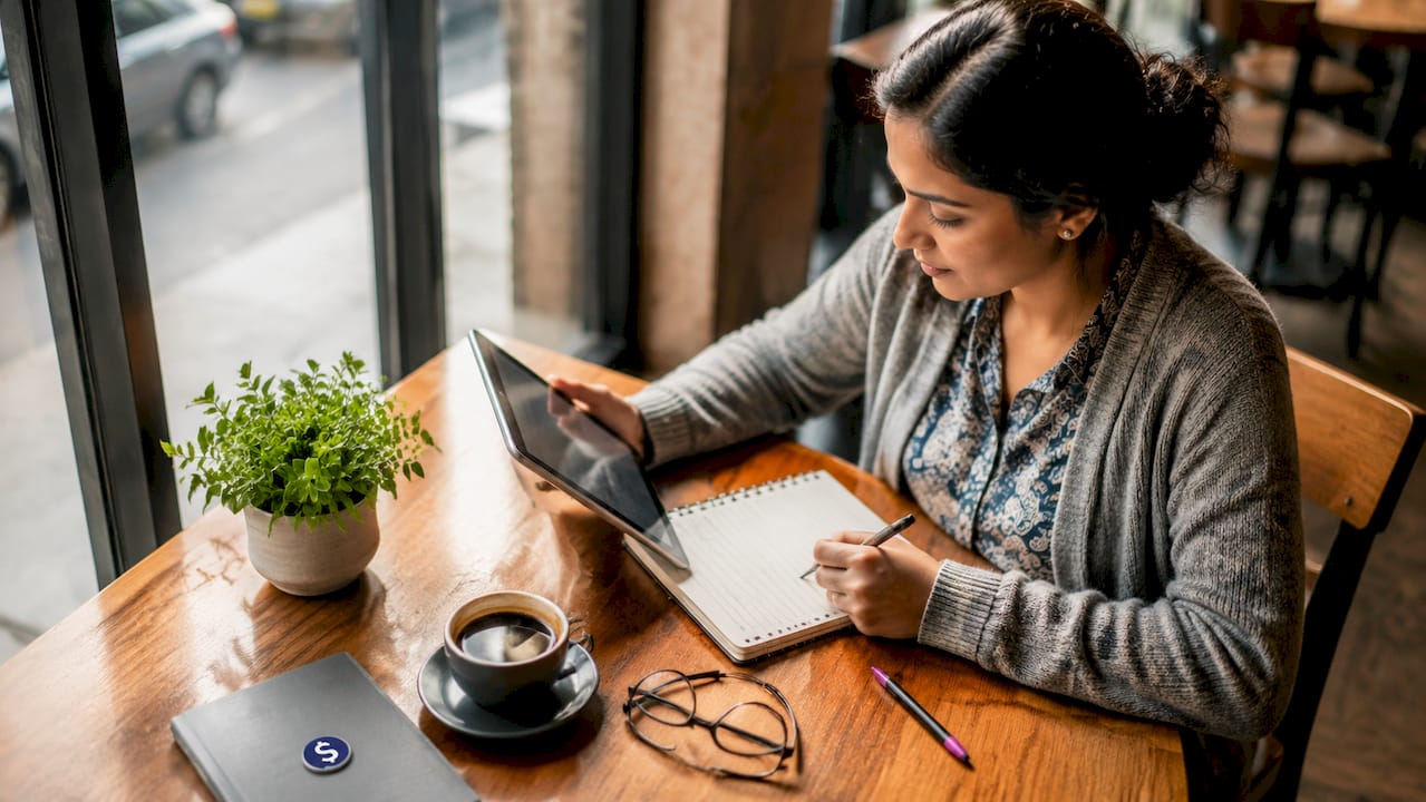 Woman comparing money transfer methods at home desk