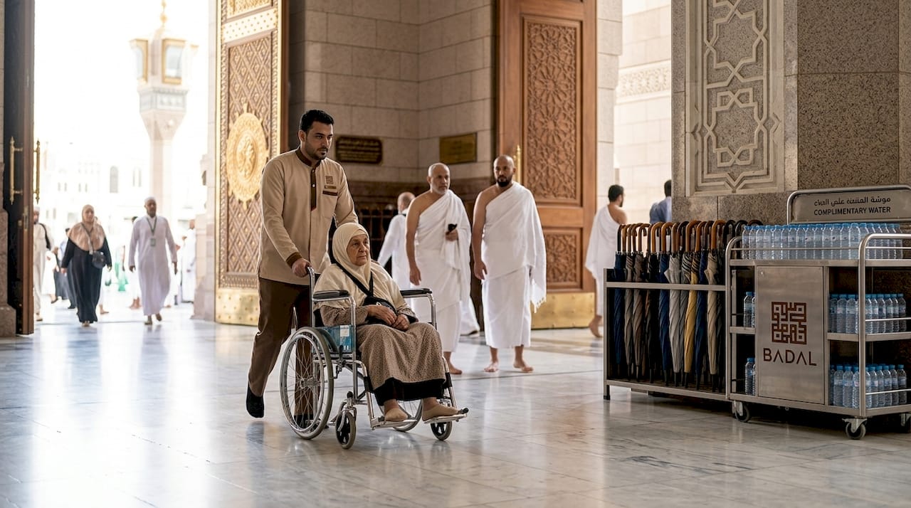 Attendant assisting elderly person in wheelchair at mosque entrance