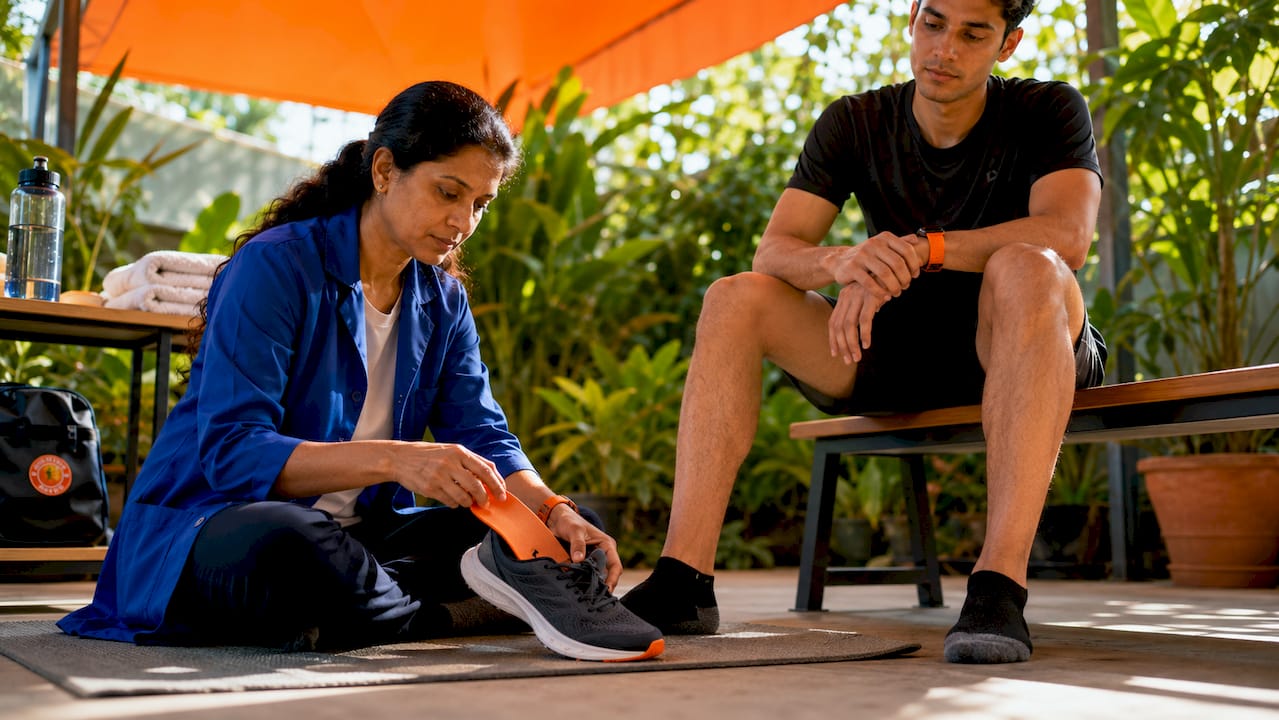 Podiatrist fitting custom insole on athlete