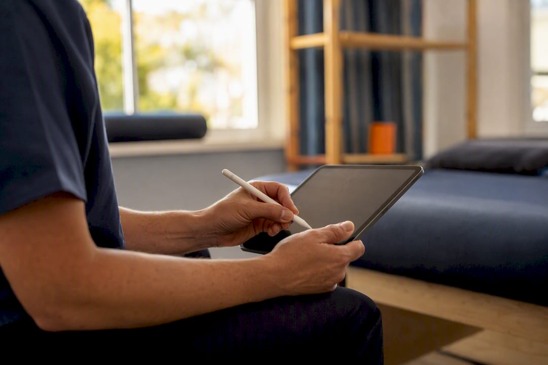Physiotherapist entering treatment notes on tablet