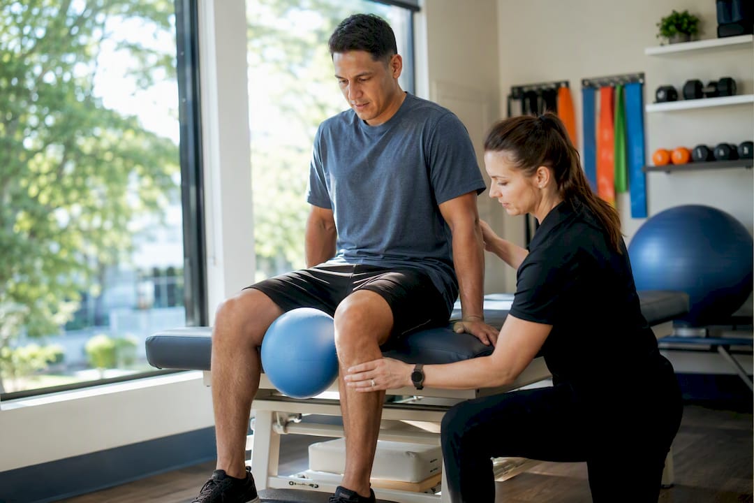 Physiotherapist assisting groin rehab exercise