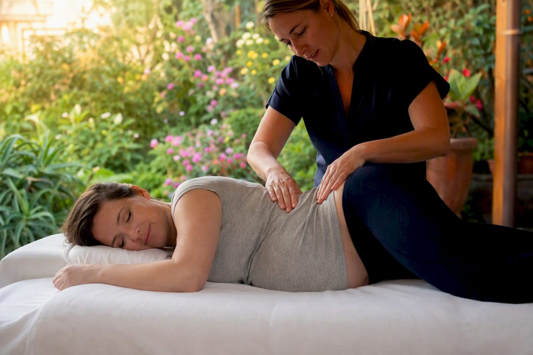Pregnant woman receiving side-lying massage therapy