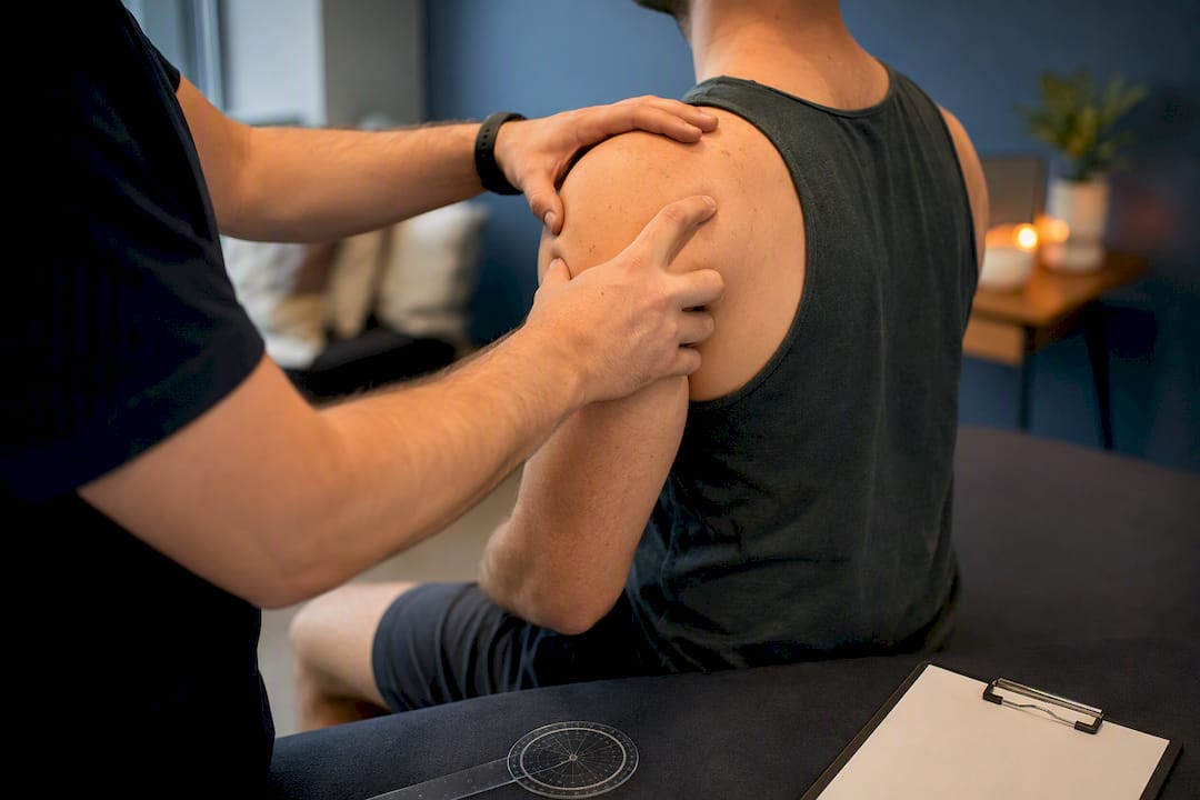 Physiotherapist assessing shoulder muscles