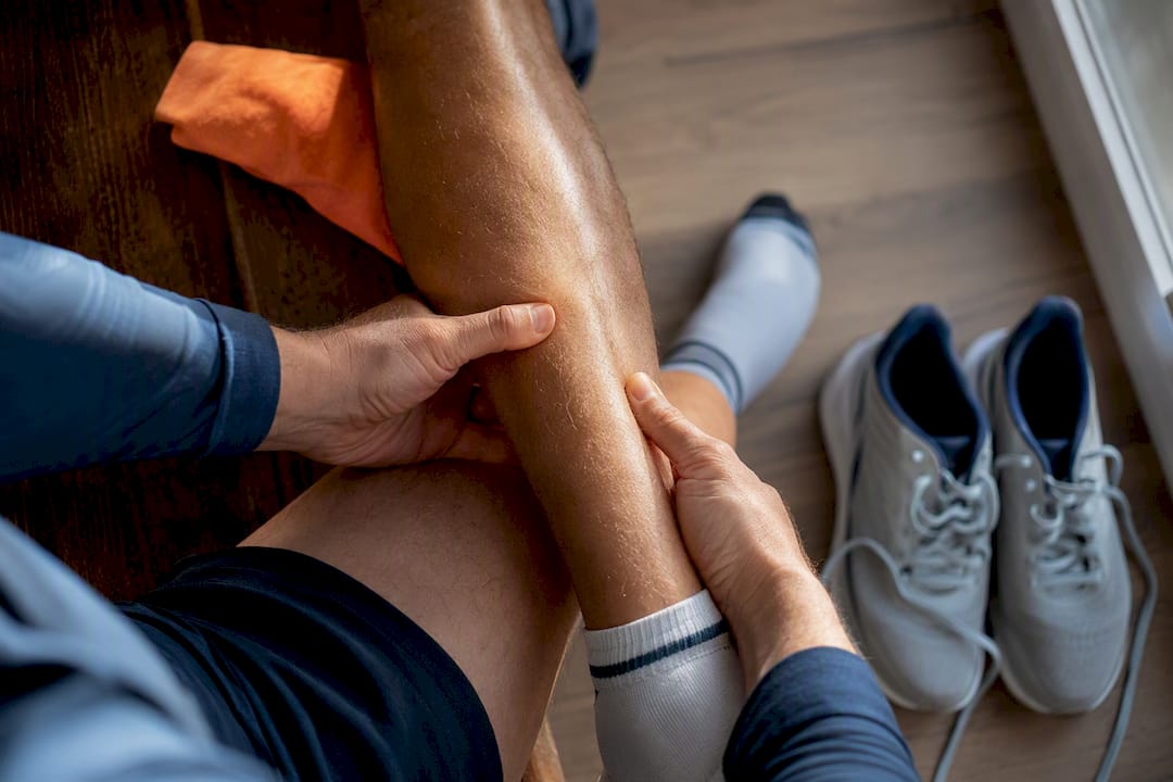 Runner checking tenderness along shin bone