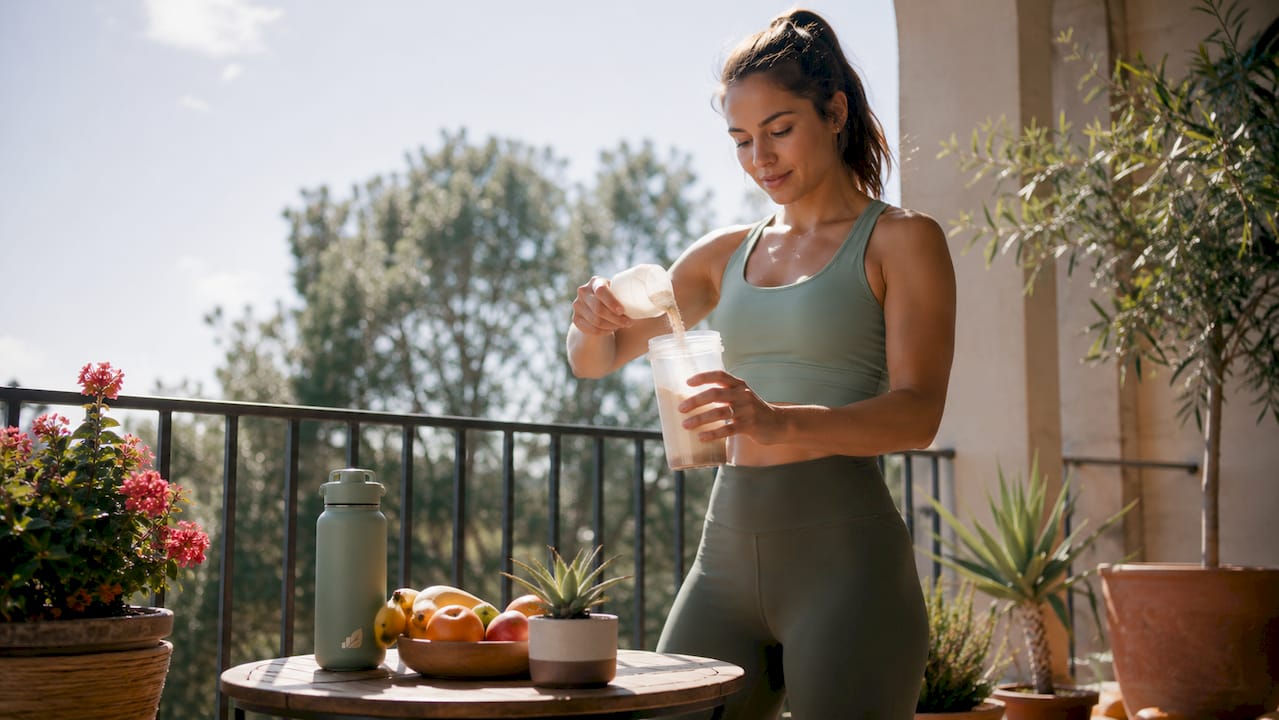 Athlete preparing protein shake in kitchen