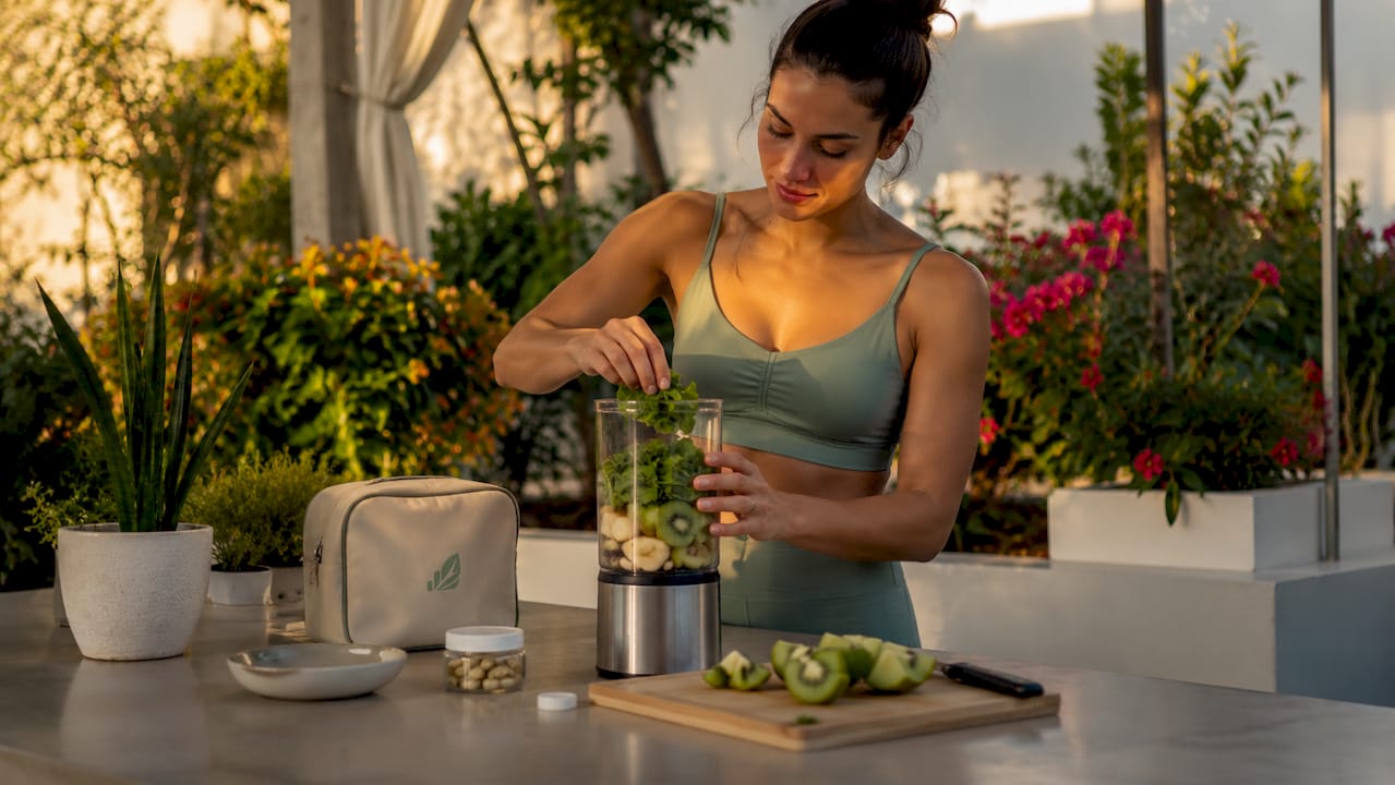 Athlete preparing vitamin smoothie indoors