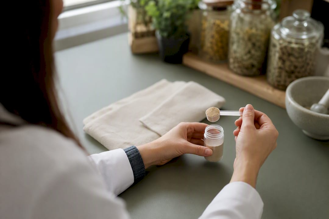 Hands preparing yeast probiotic capsule dose