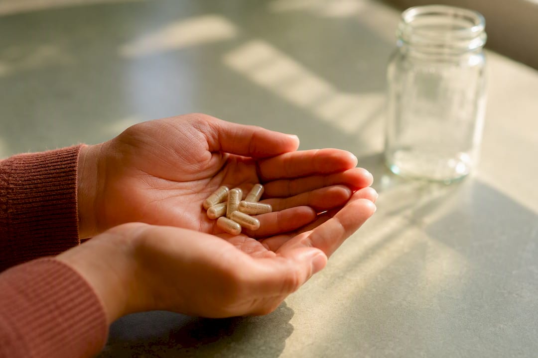 Hands holding probiotic capsules for dosage