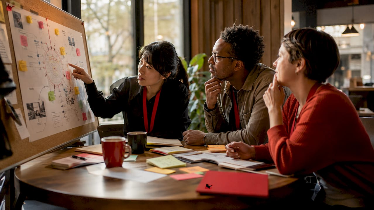 Team reviewing research frameworks around conference table