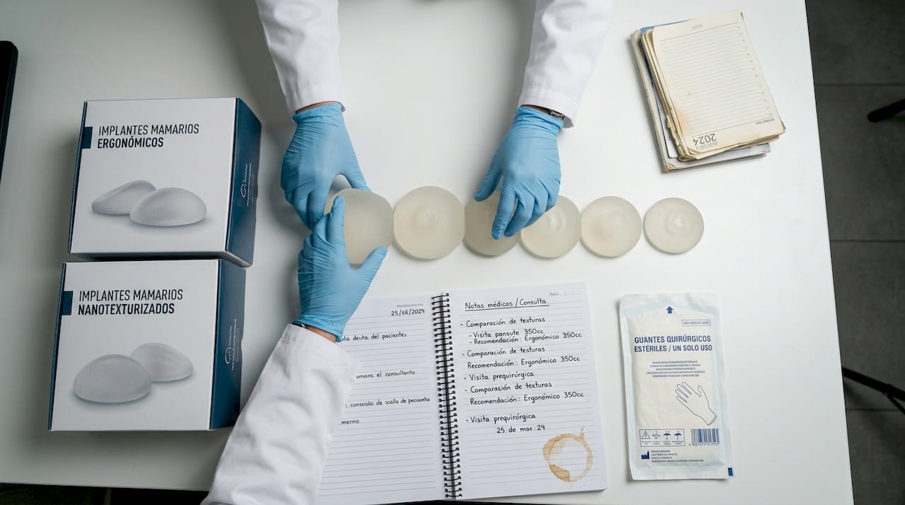 Distintos tipos de implantes mamarios expuestos sobre la mesa de una clínica
