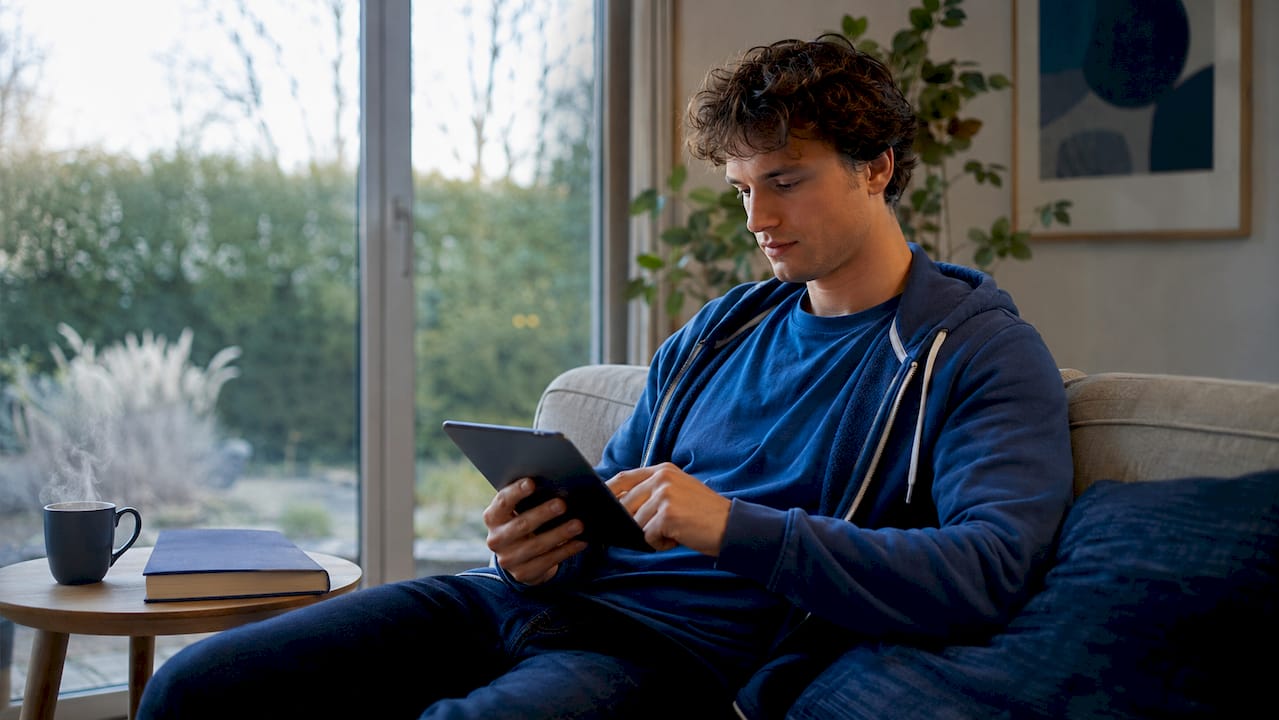 Jonge man die via zijn tablet bezig is met het leren van een taal door regelmatig te herhalen.