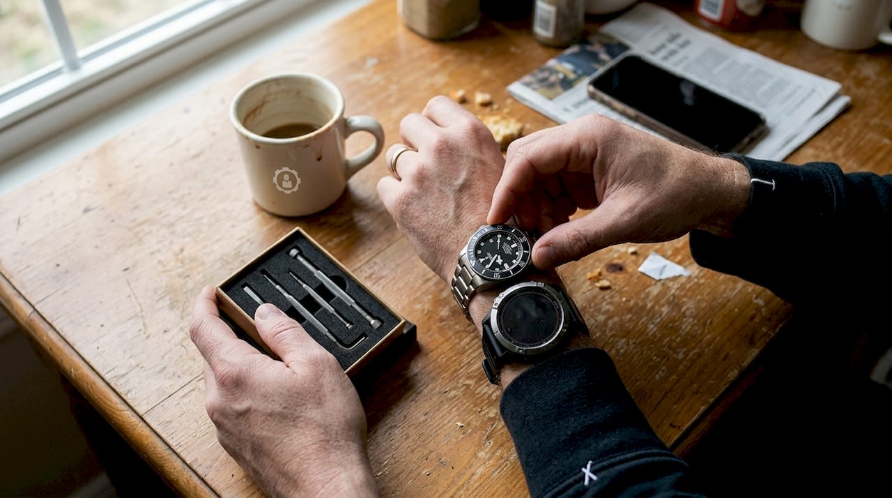 Hands stacking Tudor Pelagos and Google Pixel Watch using Smartlet adapter