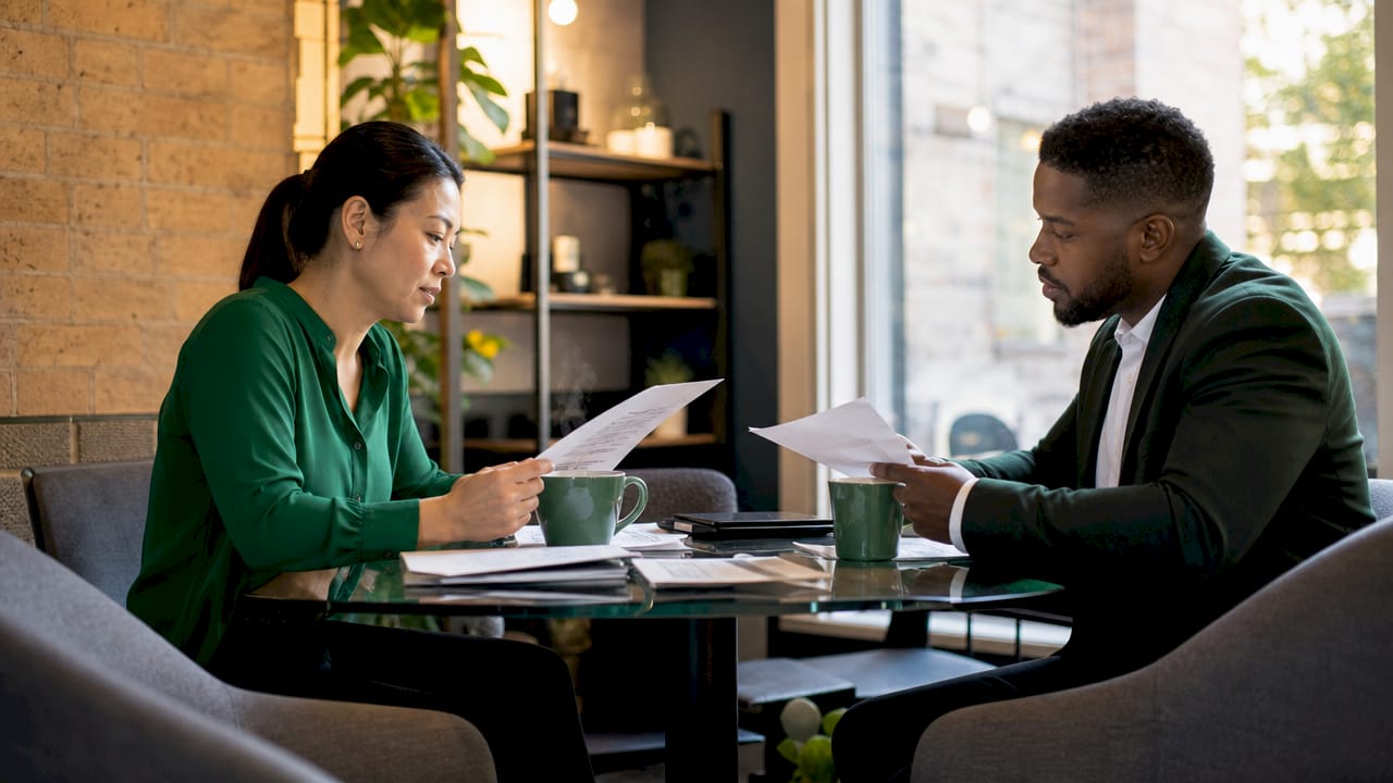 Two managers reviewing repair cost documents in office