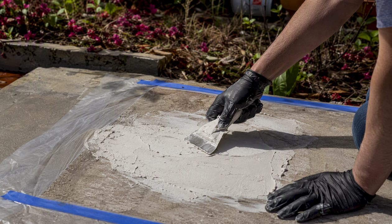 Applying poultice paste on concrete efflorescence